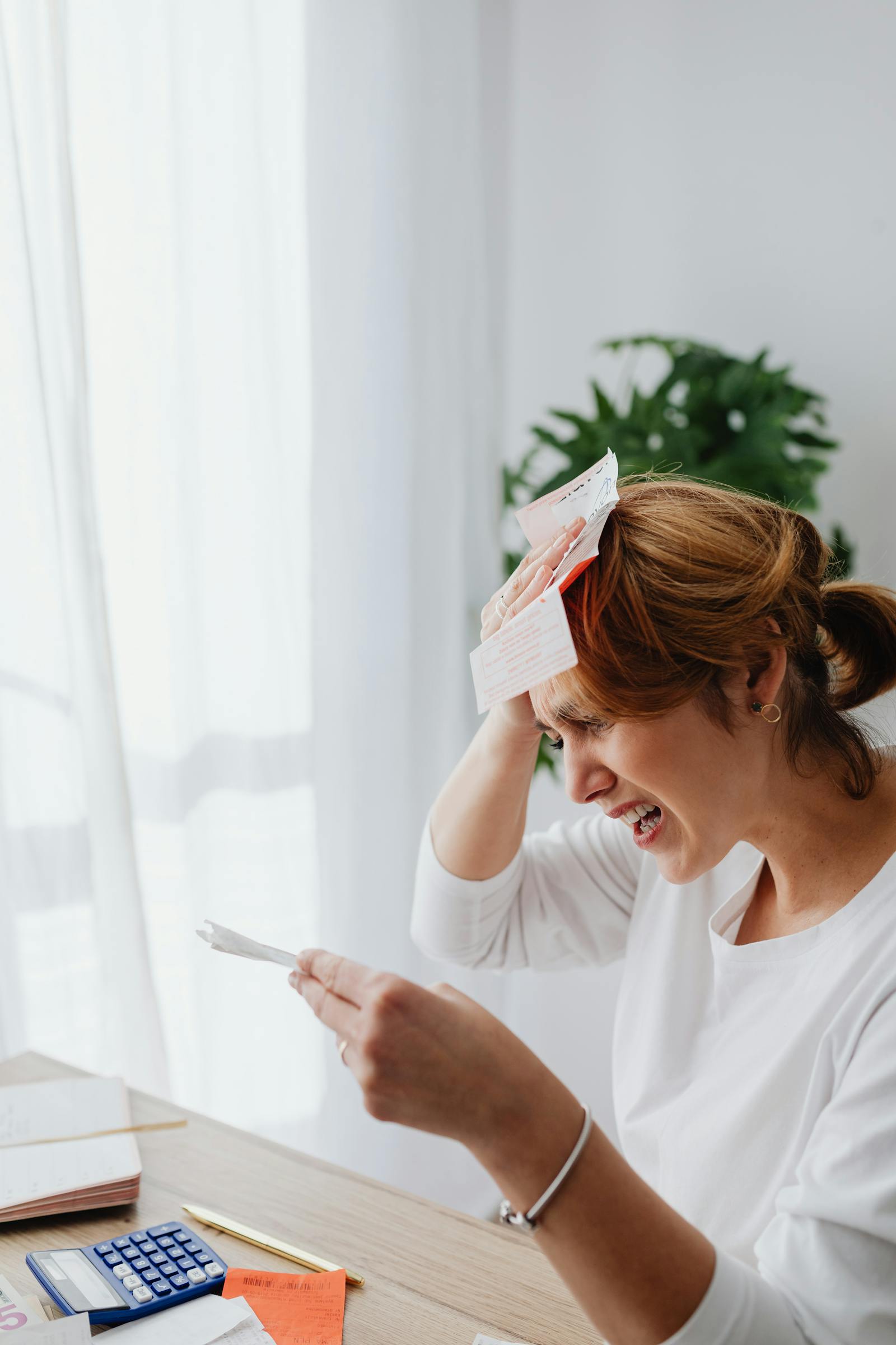 A woman holding bills while managing money pressure.